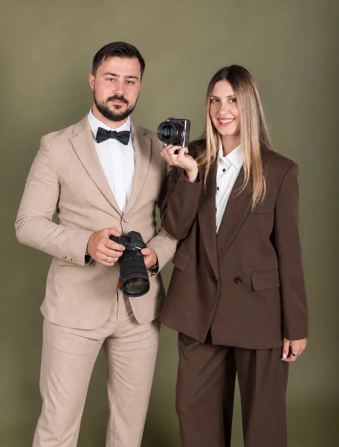 Anatoly and Julia, destination wedding photographers, holding their cameras
