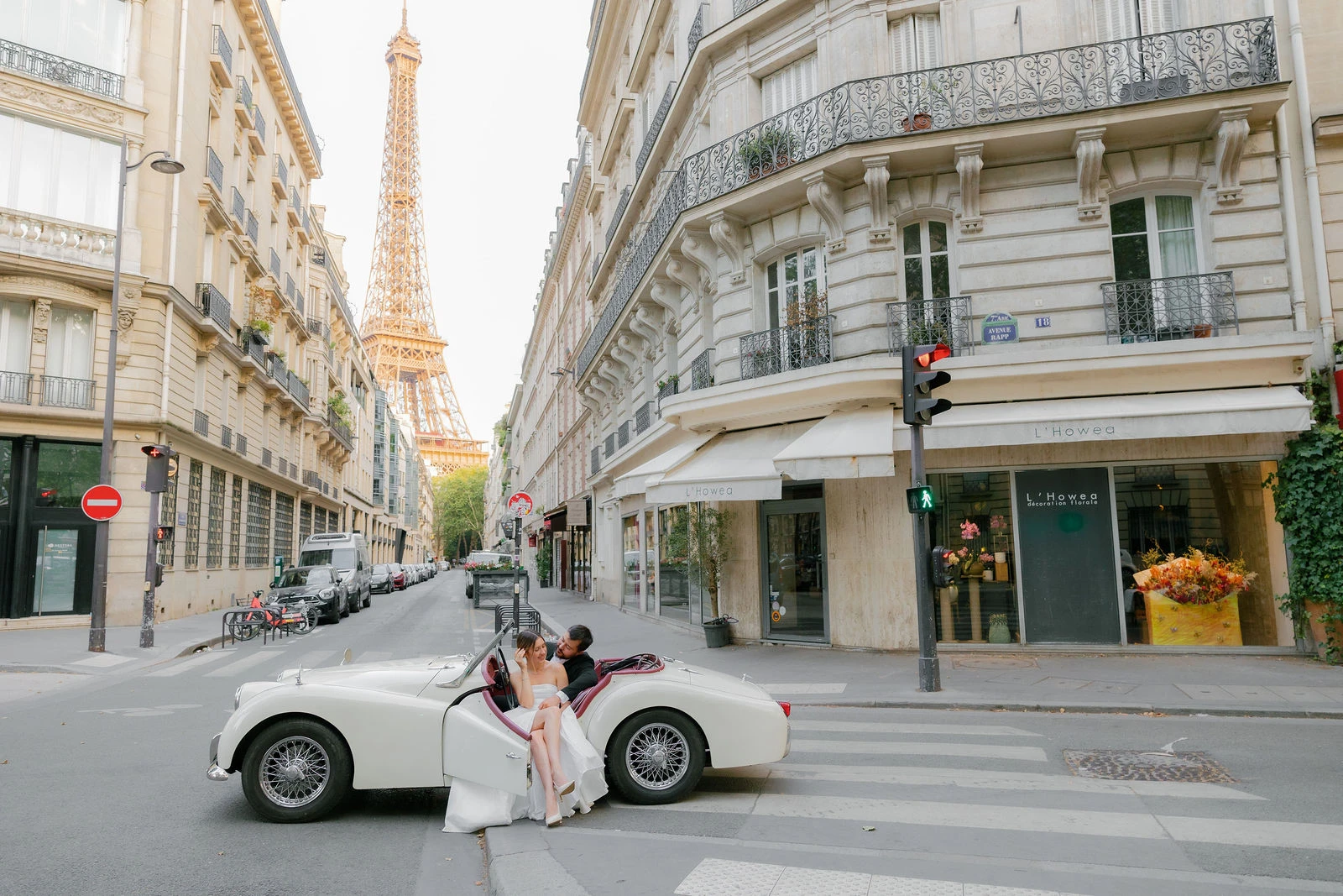 Anatoly and Julia with a white vintage roadster on a Paris street