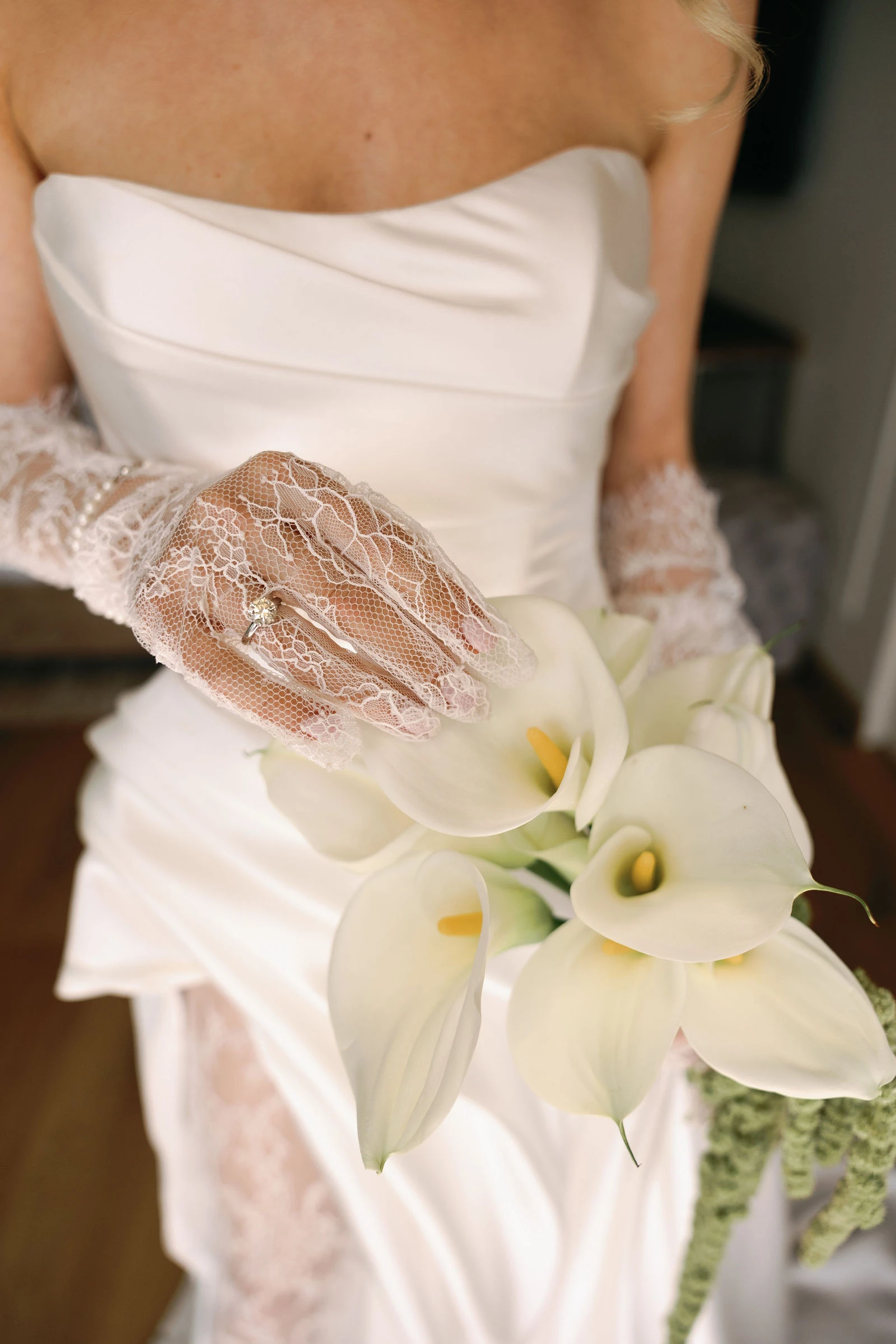 Bride in lace gloves holding white calla lilies, Lake Garda