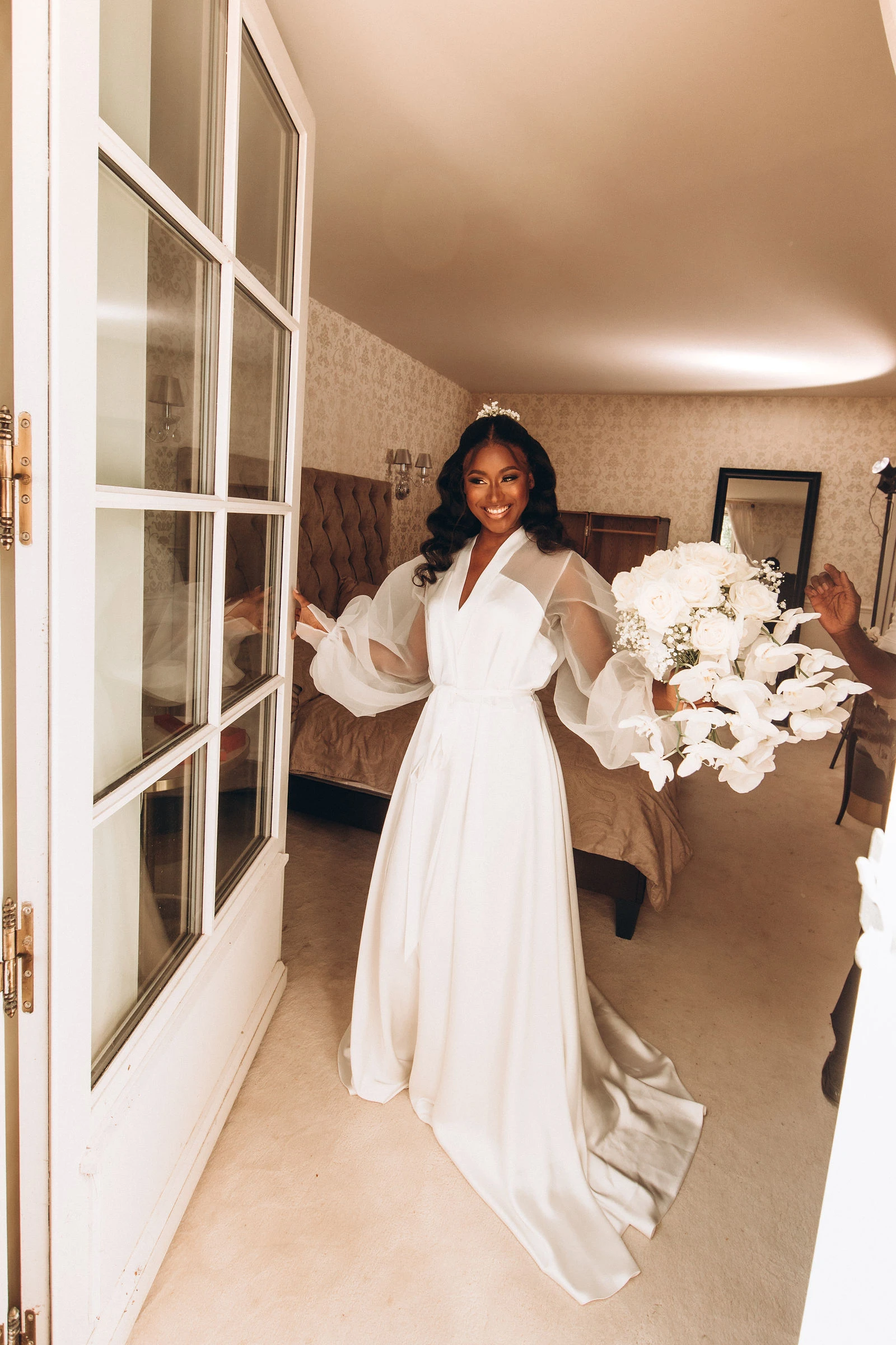 Bride in her dress by the window