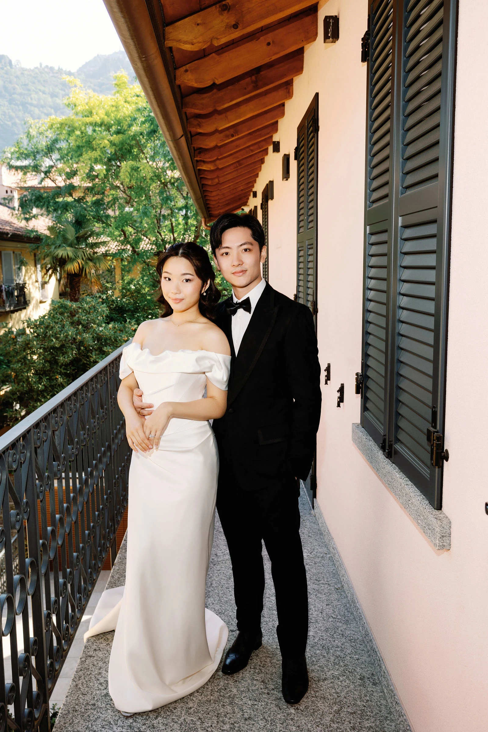 Bride and groom on a balcony over the rooftops of Como