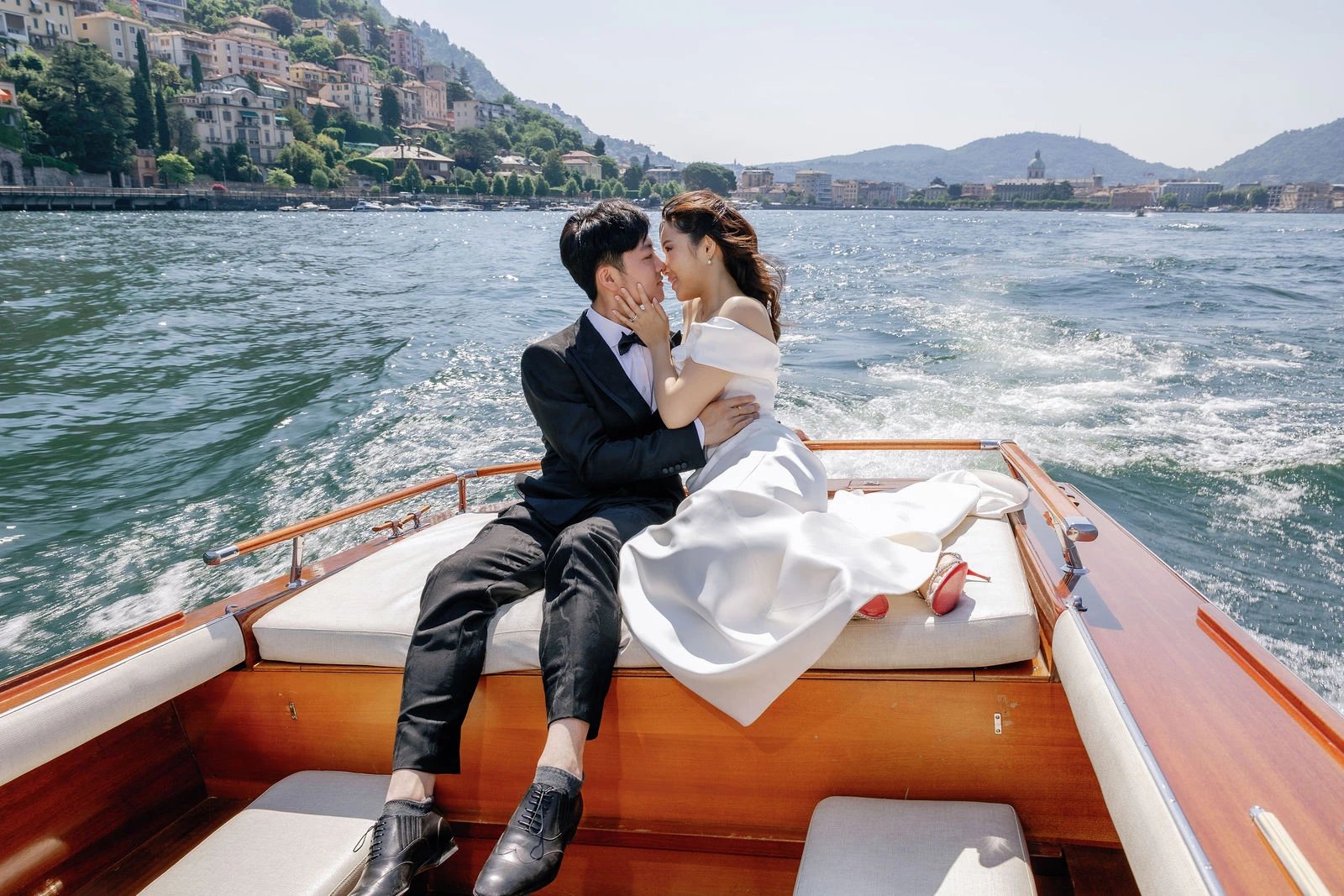 Couple on a wooden boat crossing Lake Como