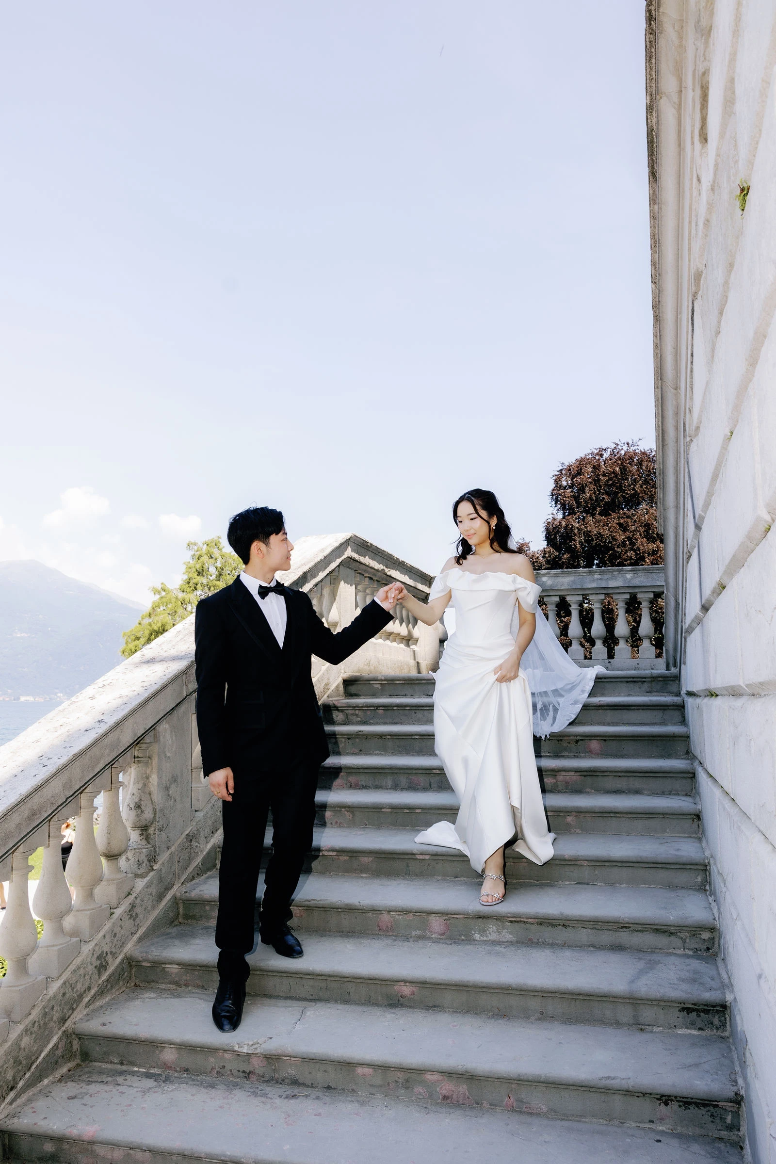 Couple walking down the villa stairs to the lake