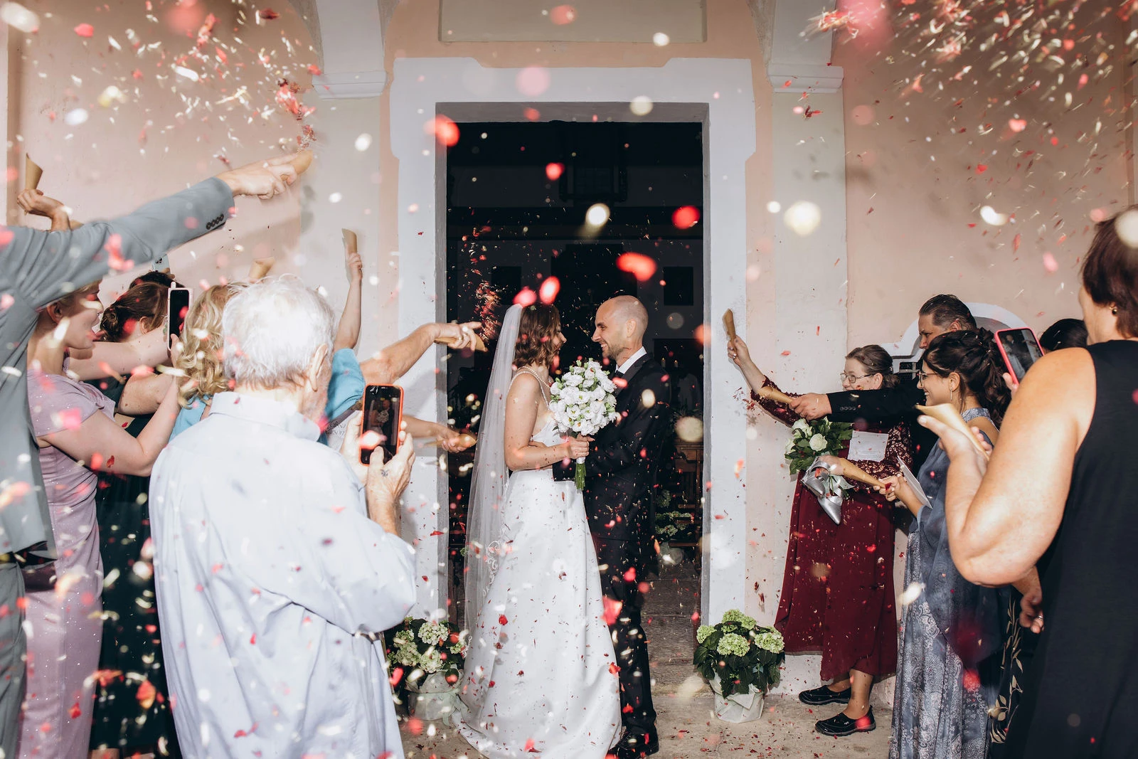 Guests throwing confetti as the newlyweds leave the church