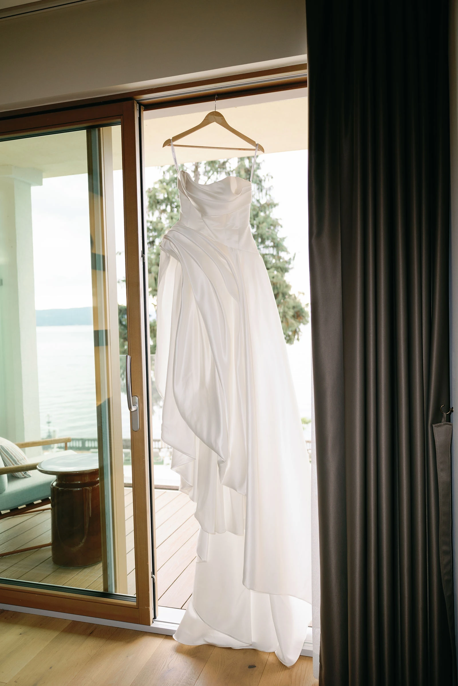 Wedding dress hanging by the window, Lake Garda