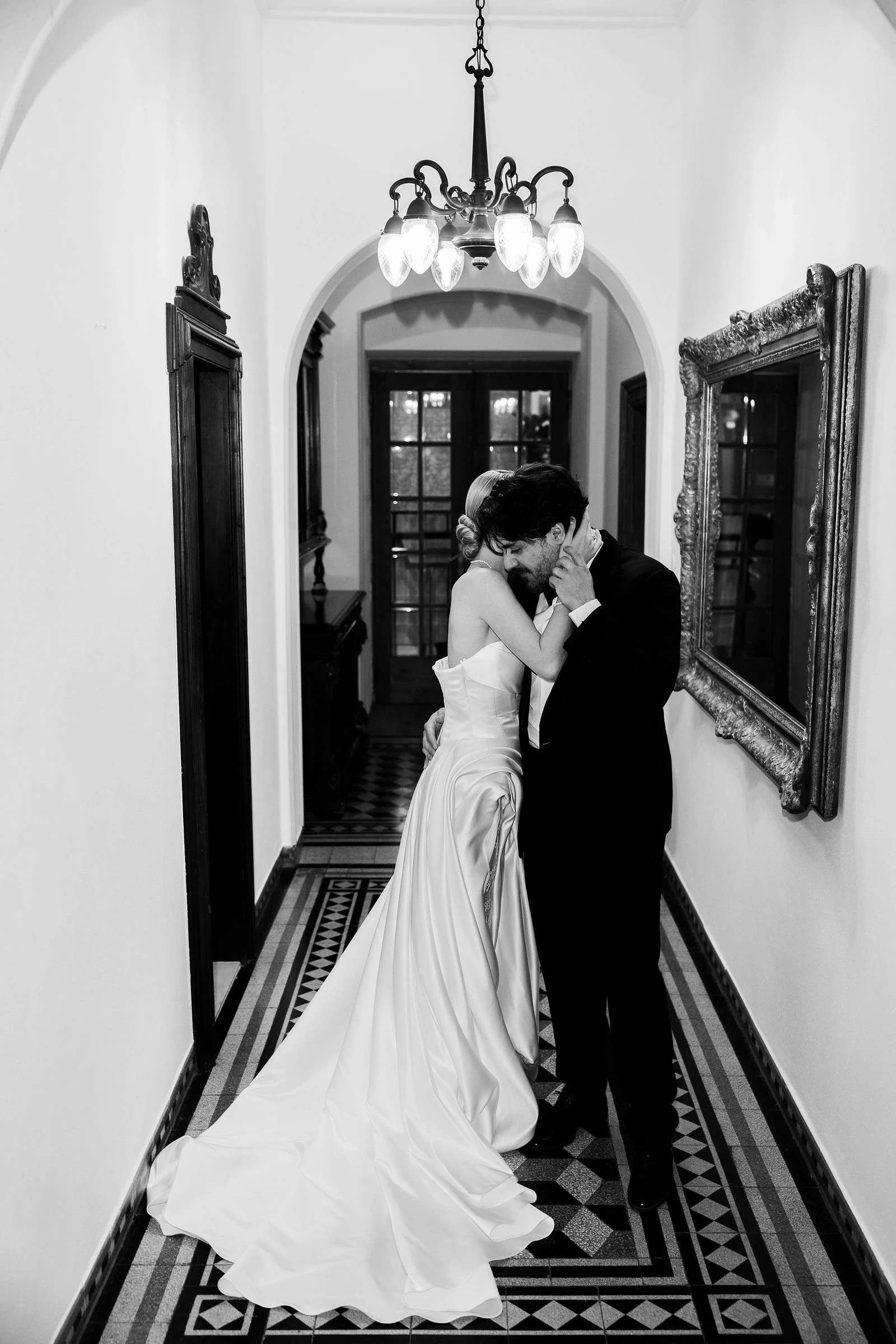 Couple under the chandelier in the hotel corridor