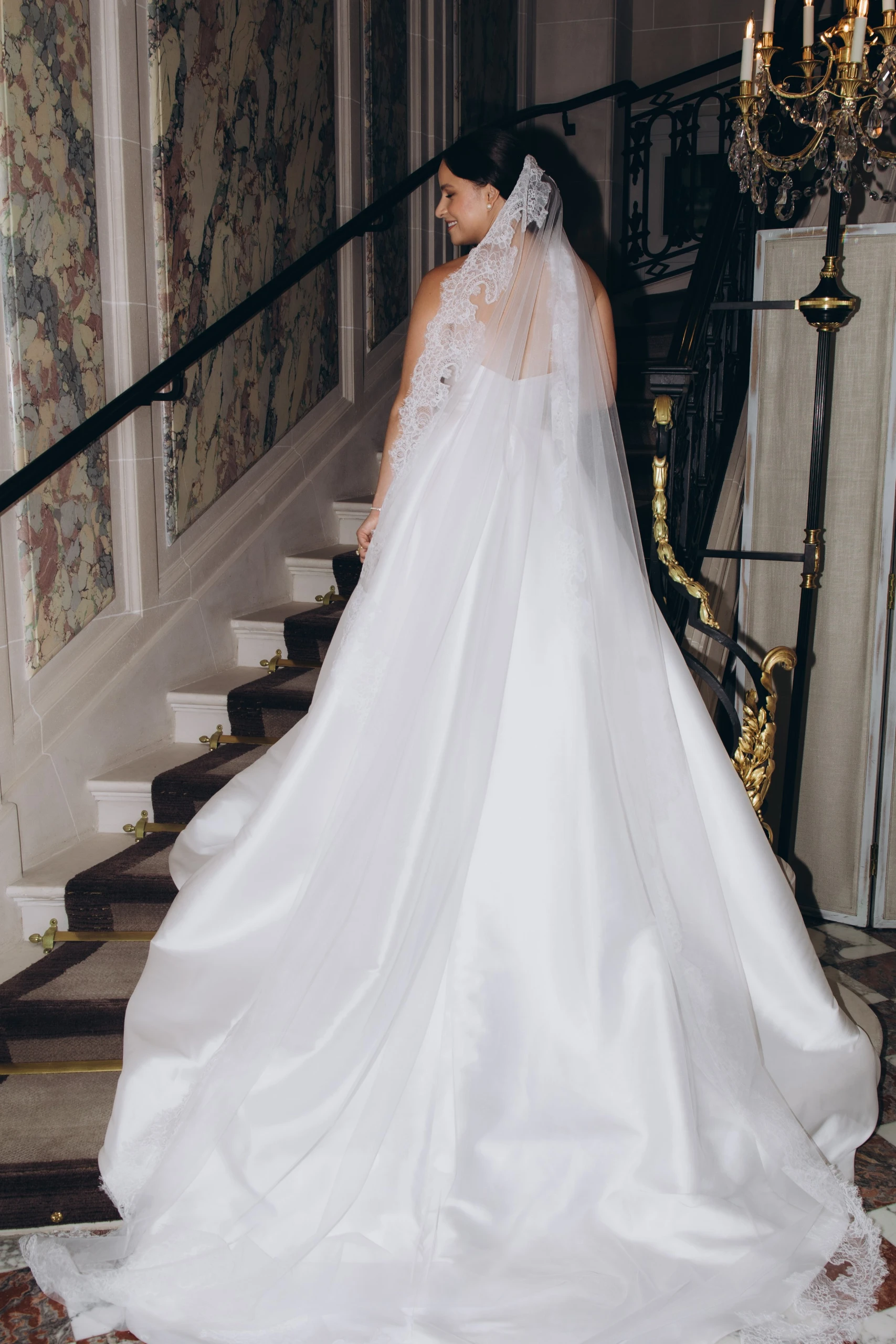 Bride on the marble staircase, the train spread behind her
