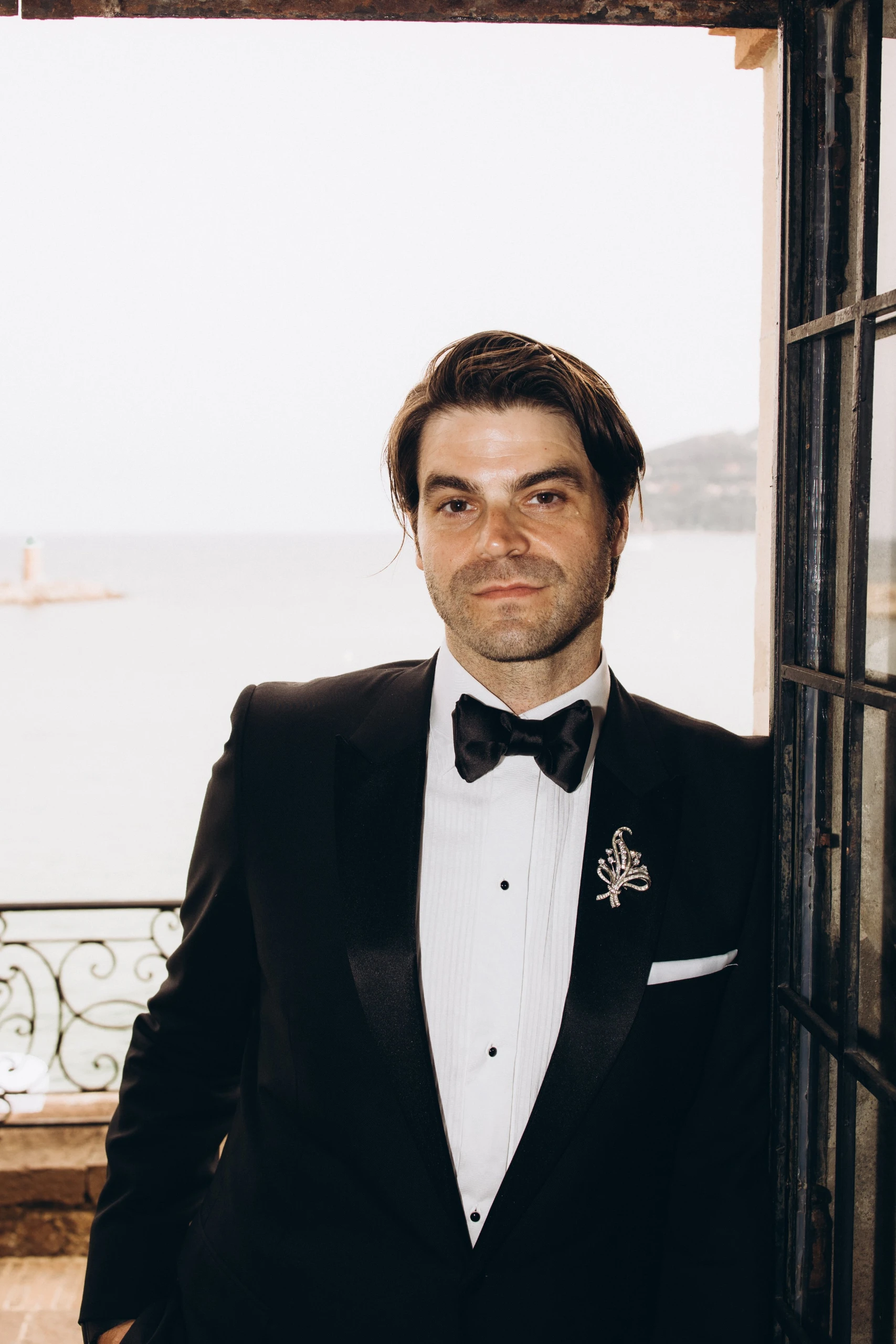 Groom by a window over the Mediterranean