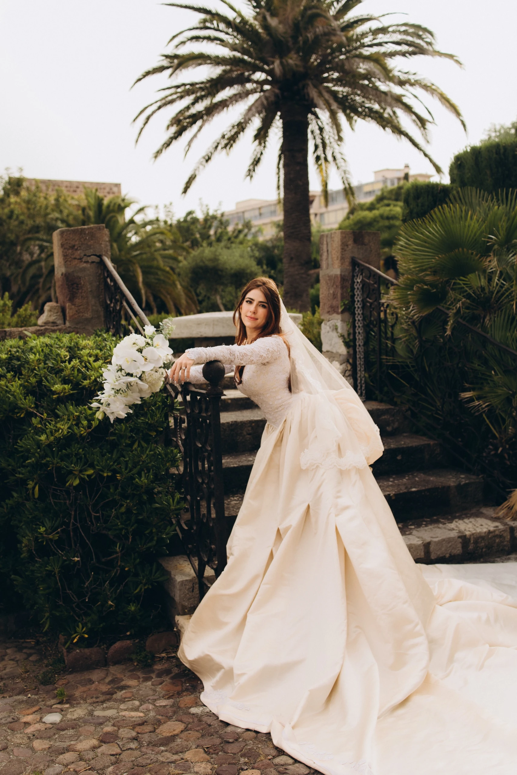 Bride in the castle garden under the palms
