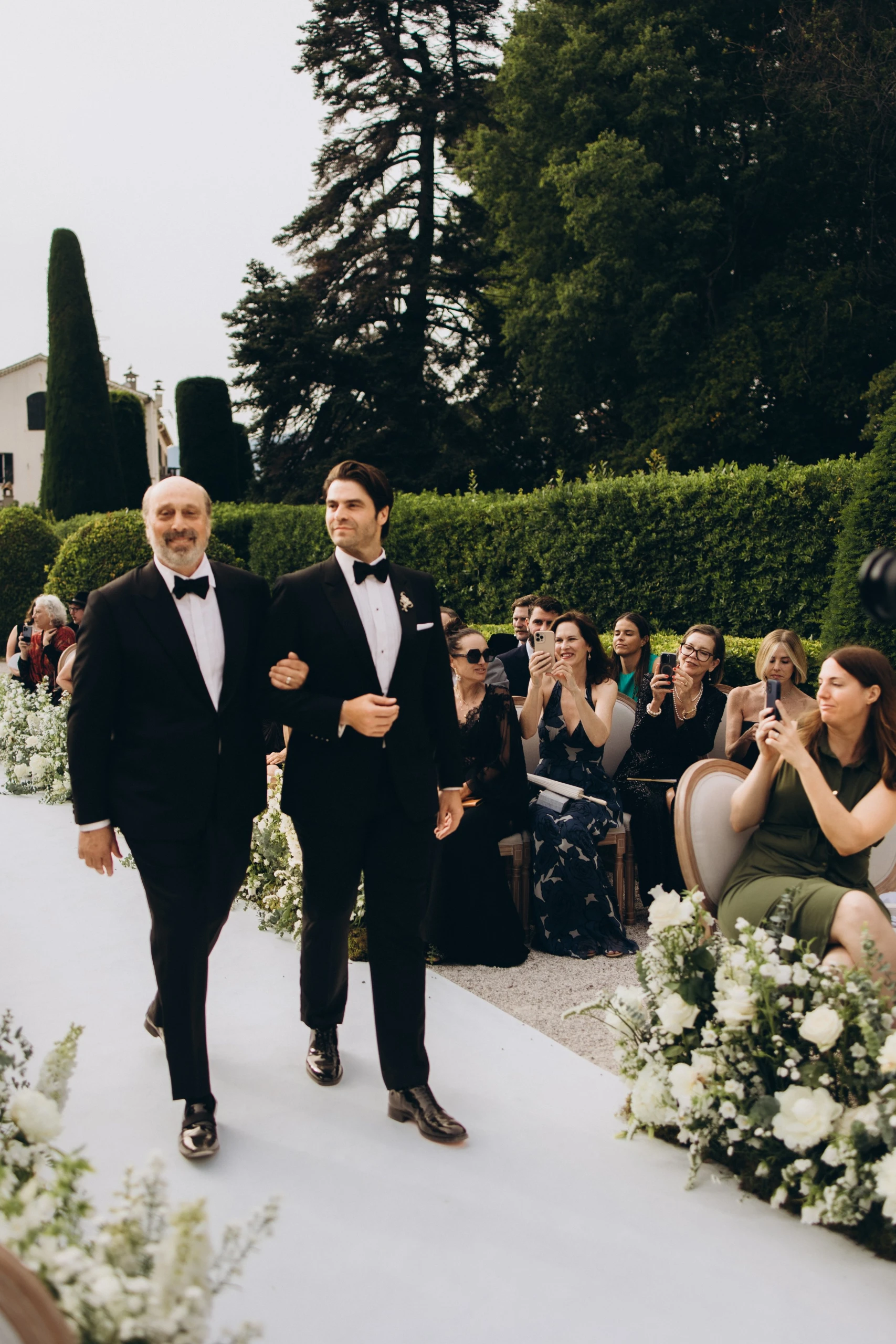 Groom walking down the aisle with his mother
