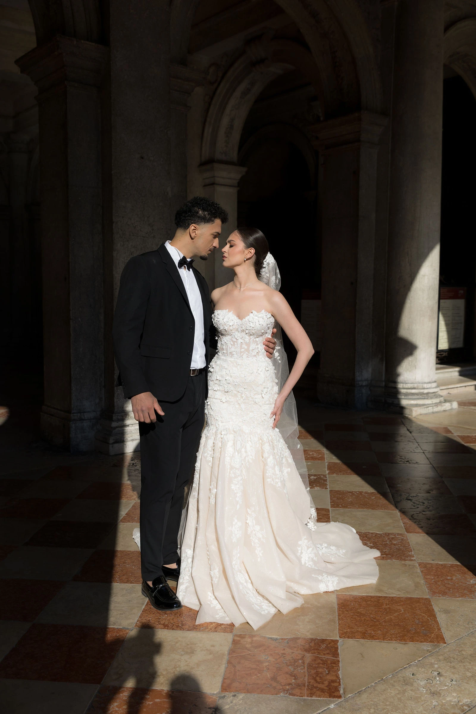 Couple in a dark stone portico, Venice