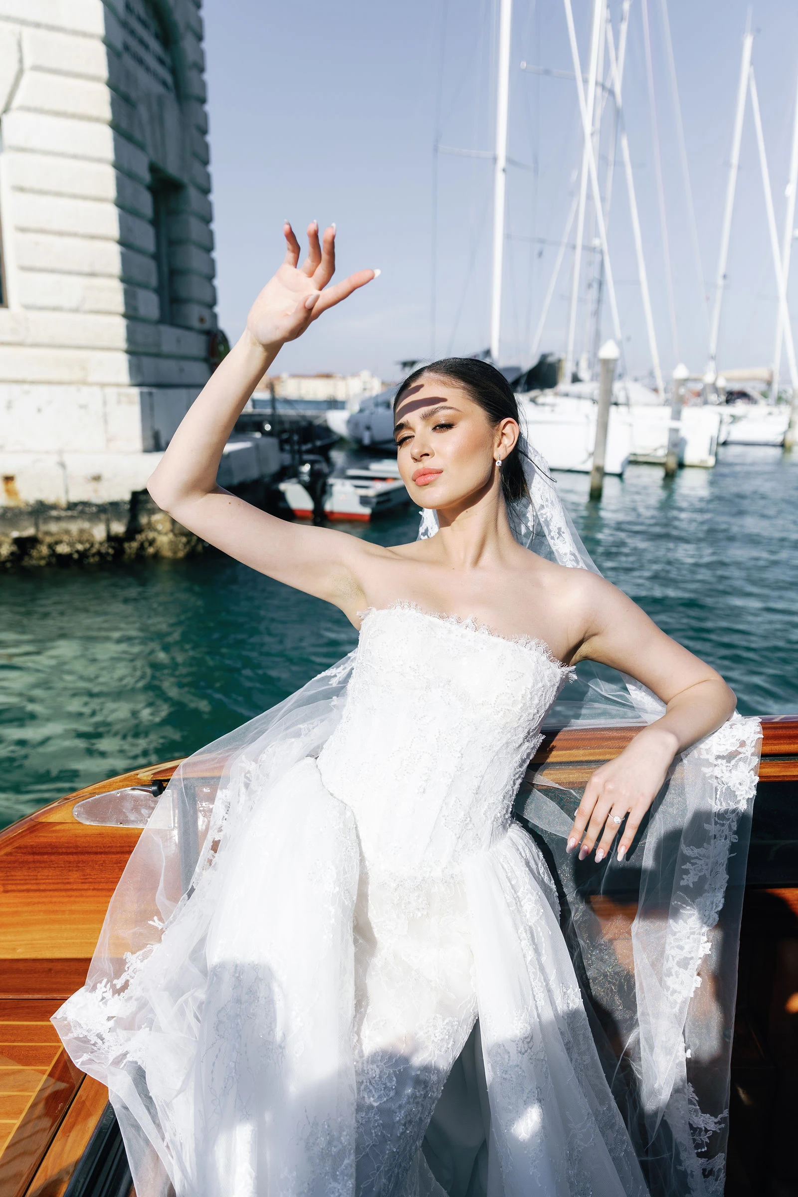 Bride on the waterfront with sailboat masts behind, Venice